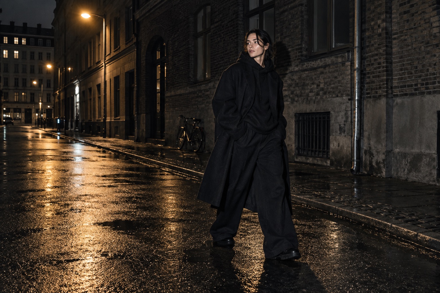 Person i lagdelt sort streetwear under en gadelygte