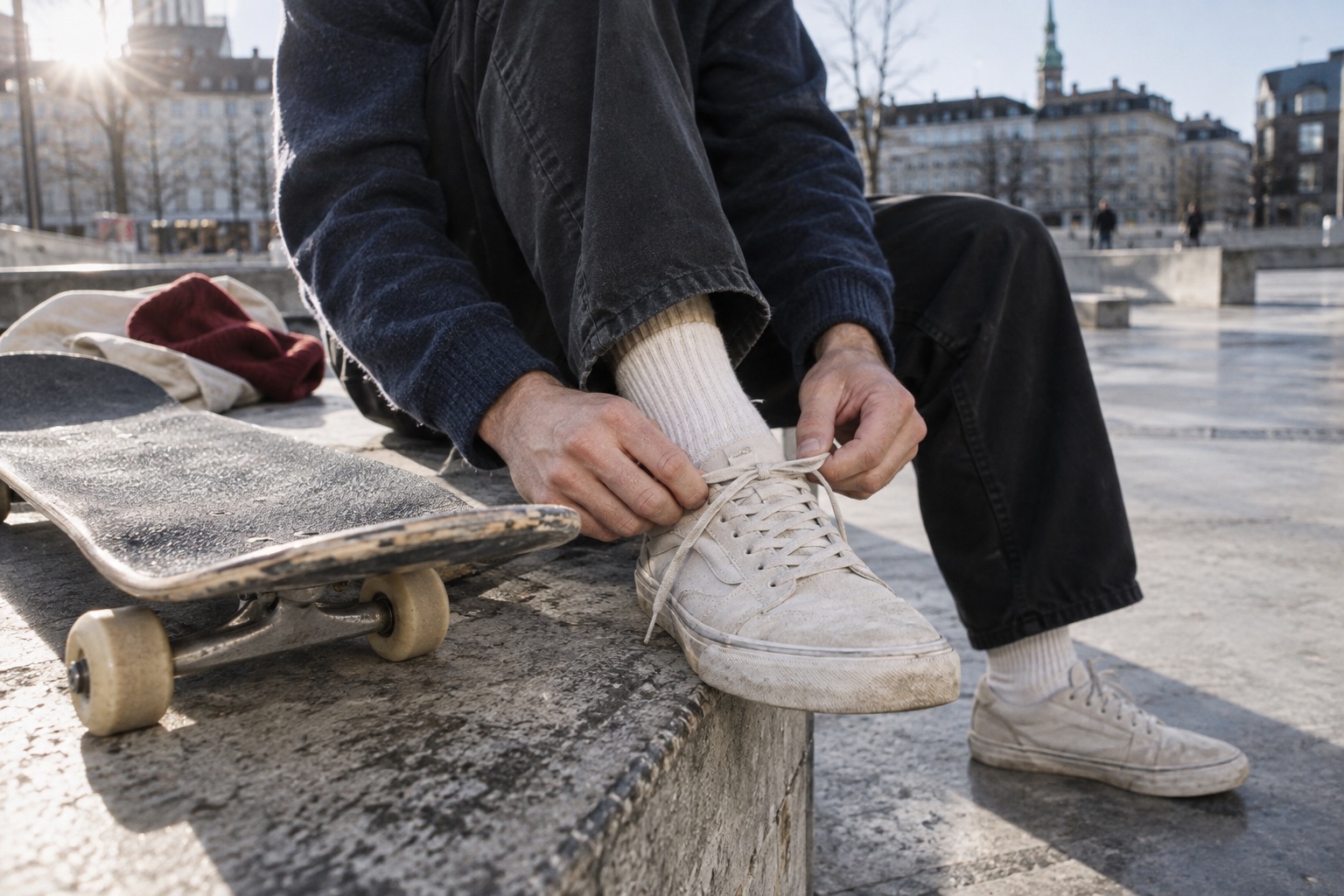 Skater binder sine skatesko ved en betonrampe